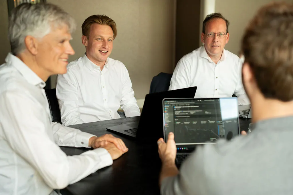Teamoverleg van ITsmart aan de vergadertafel met laptops