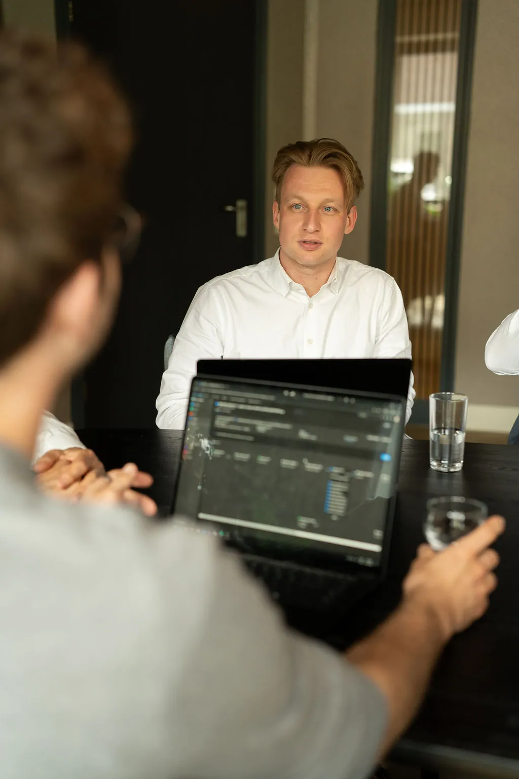 Collega van ITsmart achter een laptop met code en een dashboard