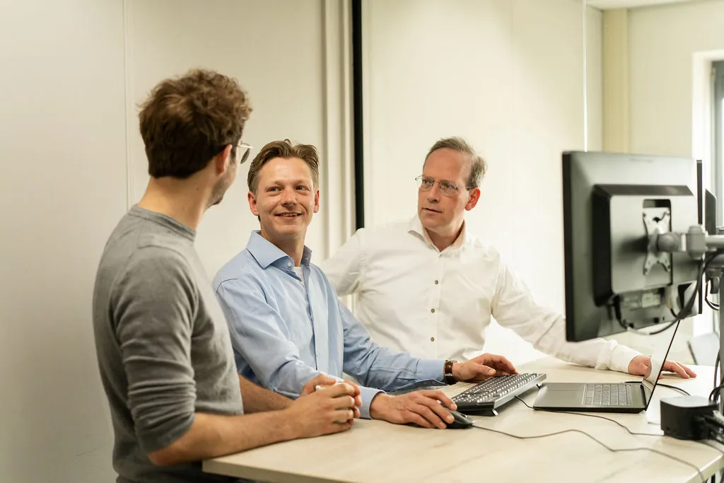 Drie ITsmart-collega's overleggen bij een beeldscherm